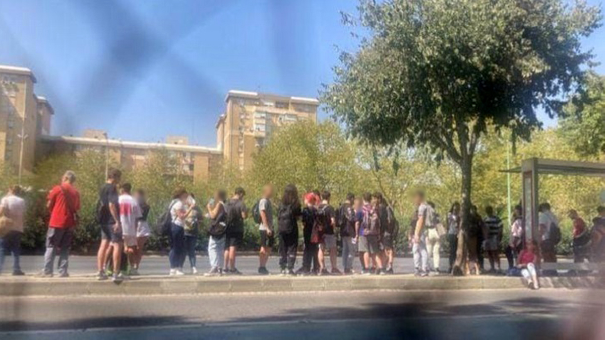Estudiantes esperando autobús a Sevilla en una parada de Carmona